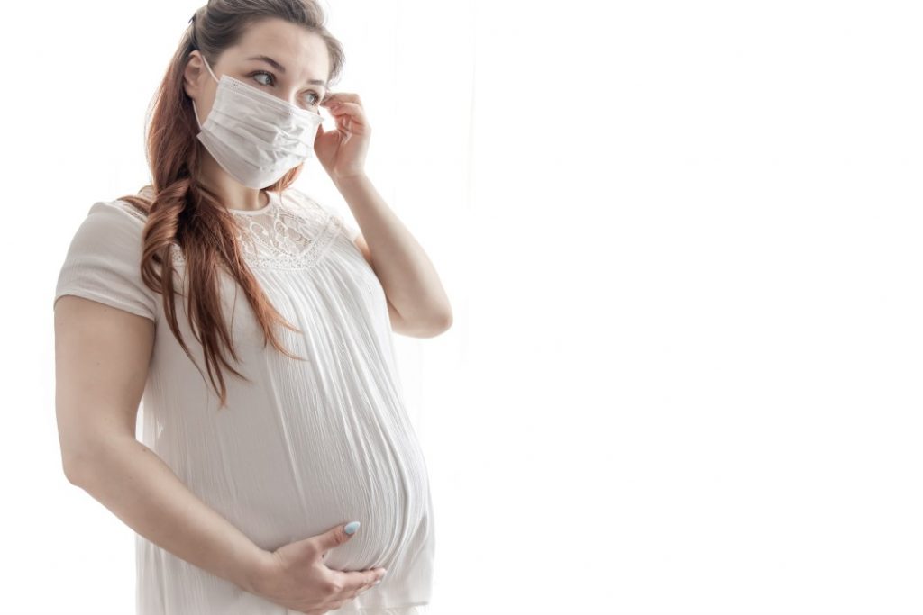 gestante na pandemia - gestante usando uma máscara médica